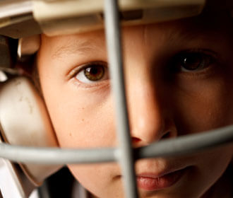 Up Close Image of A Child Wearing a Football Helmet 