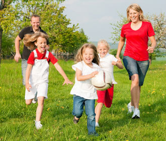 Family enjoying time playing in a grassy field