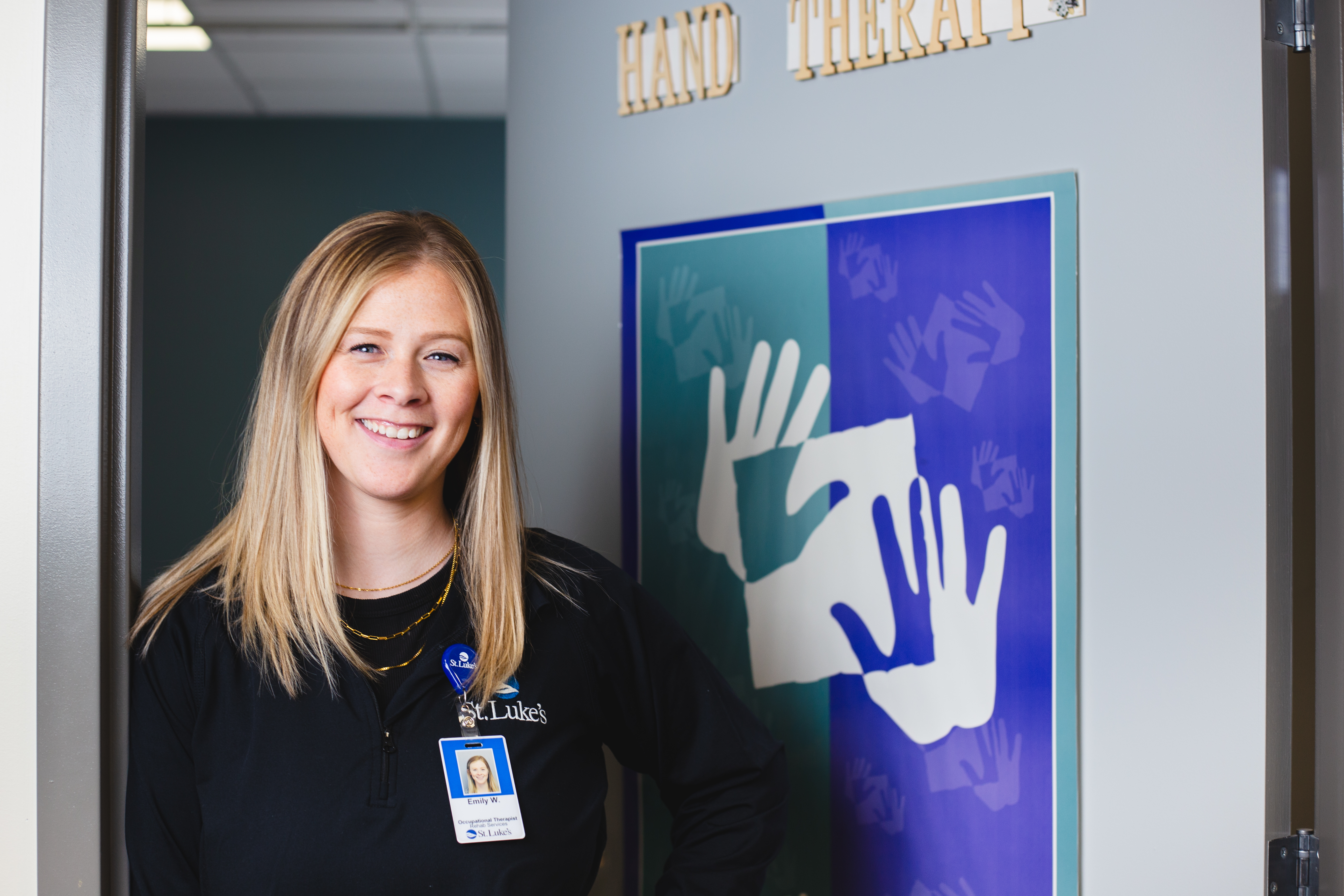 Occupational therapist leans against doorframe