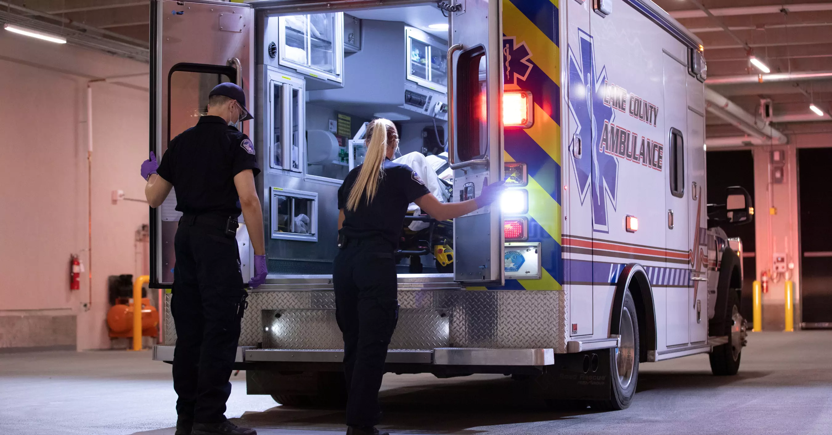 EMS staff loading a patient into an ambulance.