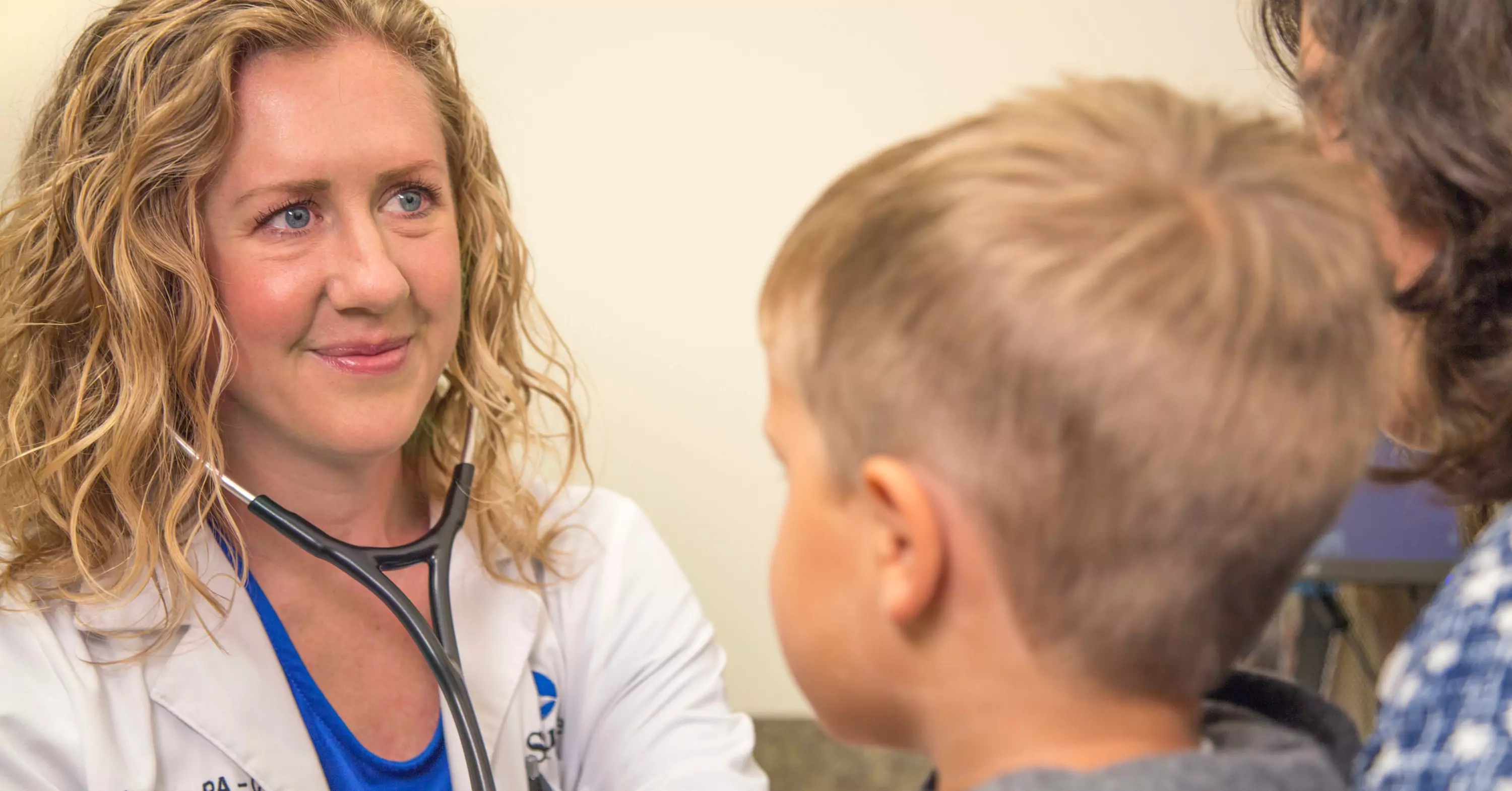 St. Luke's QCare provider smiling at child.