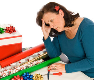 Woman Looking Stressed While Wrapping Presents 