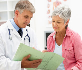 A Woman Looking Over Documents With Her Doctor