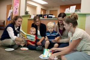 Dr. Heather Winesett reads a book with the children and parents at their two-year well-child check, during the group part of the visit.