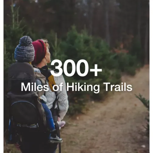 Woman hiking with child on Duluth trail with text overlaying that says "300+ Miles of Hiking Trails"
